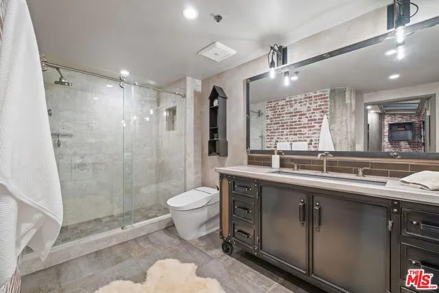 a bathroom with a double vanity sink toilet and shower