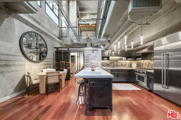 a kitchen with stainless steel appliances granite countertop a stove and a wooden floors