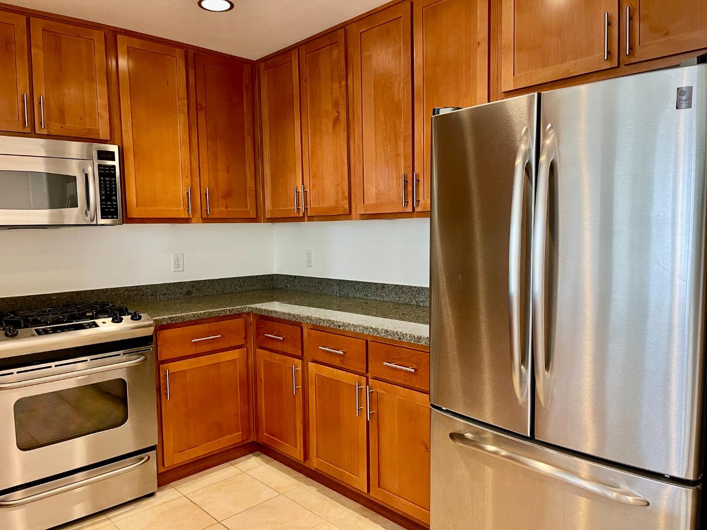 423 7th Street, Unit 516 Oakland, CA 94607 - Photo 11 of 21 a kitchen with stainless steel appliances granite countertop a refrigerator and a stove top oven