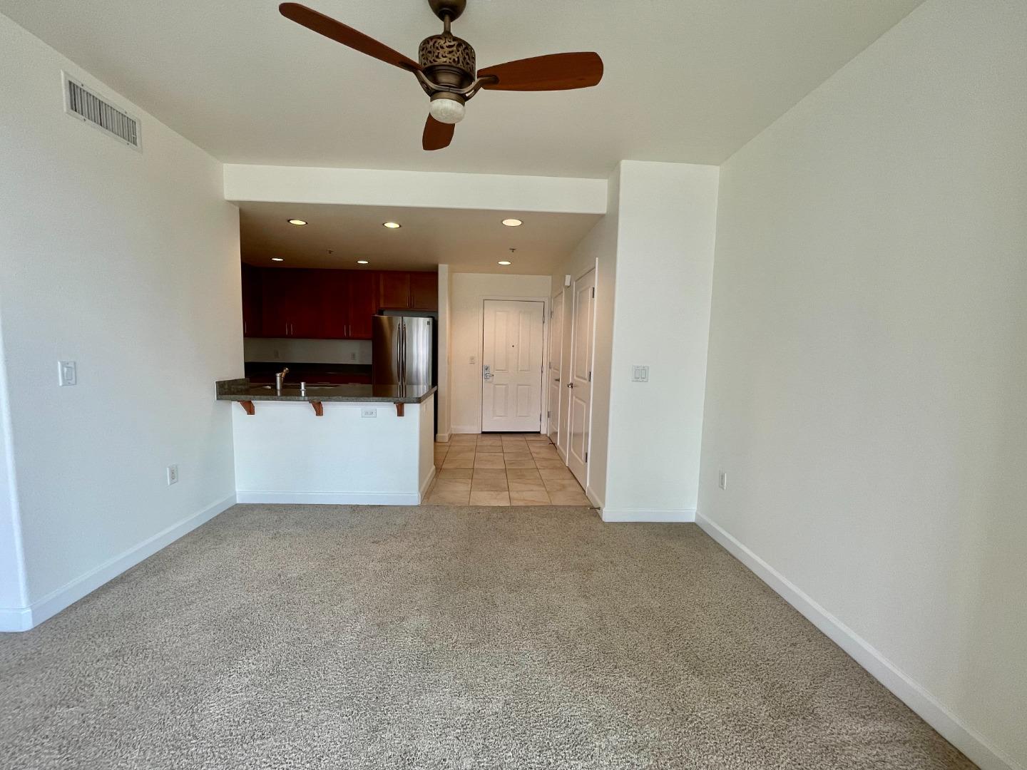 423 7th Street, Unit 516 Oakland, CA 94607 - Photo 8 of 21 a view of a livingroom with a flat screen tv and ceiling fan