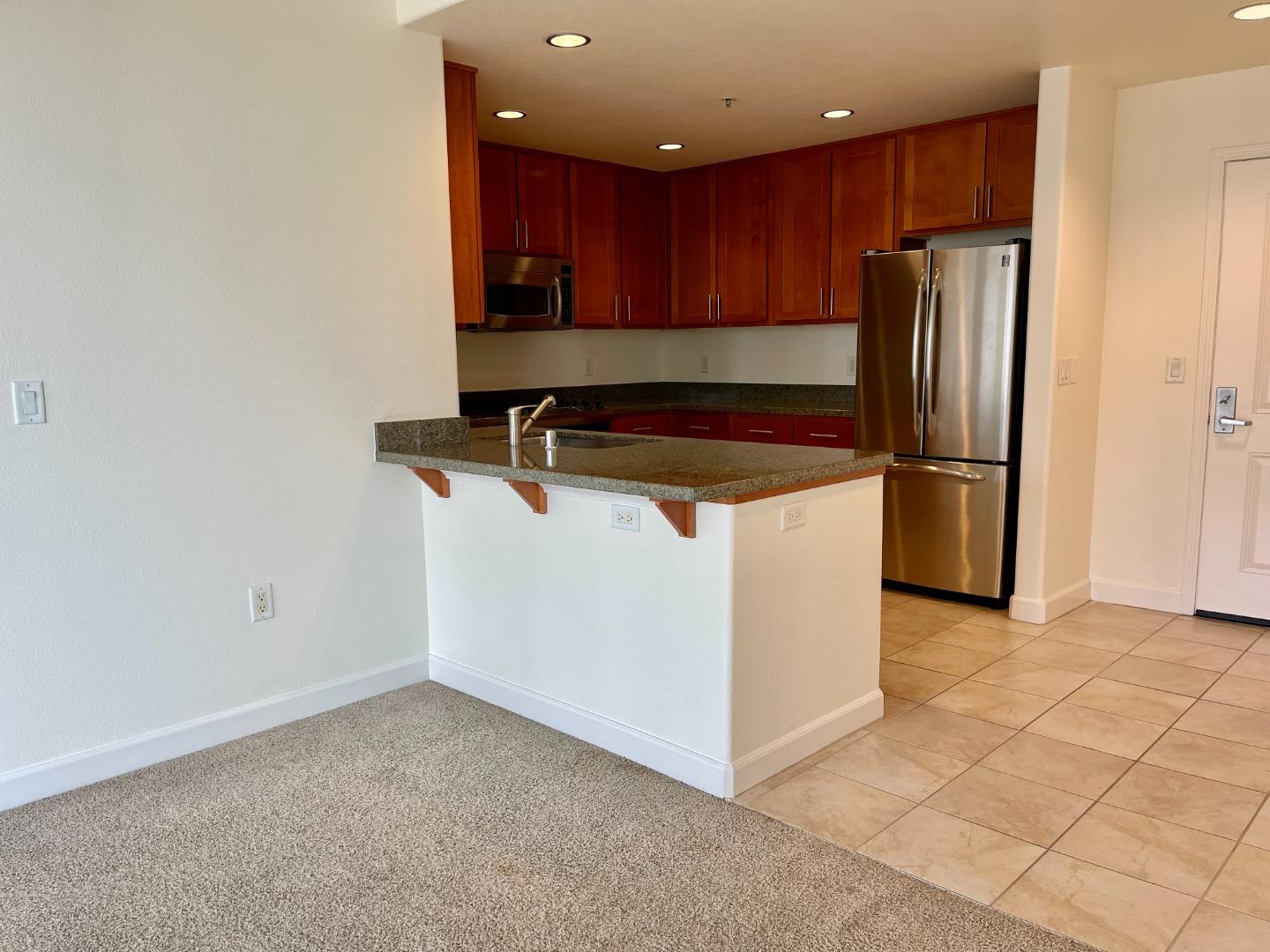 423 7th Street, Unit 516 Oakland, CA 94607 - Photo 9 of 21 a kitchen with stainless steel appliances a refrigerator and a stove top oven