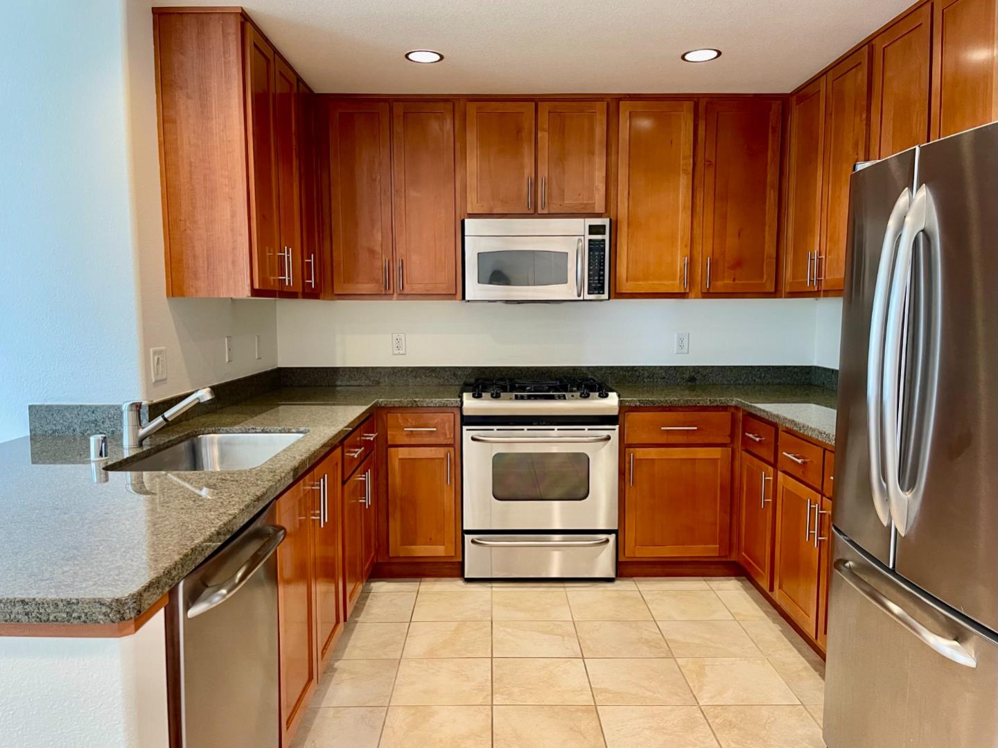 423 7th Street, Unit 516 Oakland, CA 94607 - Photo 10 of 21 a kitchen with a refrigerator sink and cabinets