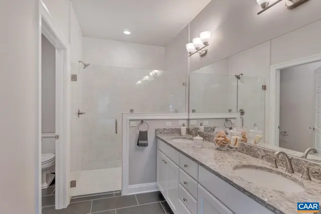 a bathroom with a granite countertop sink a shower and a mirror