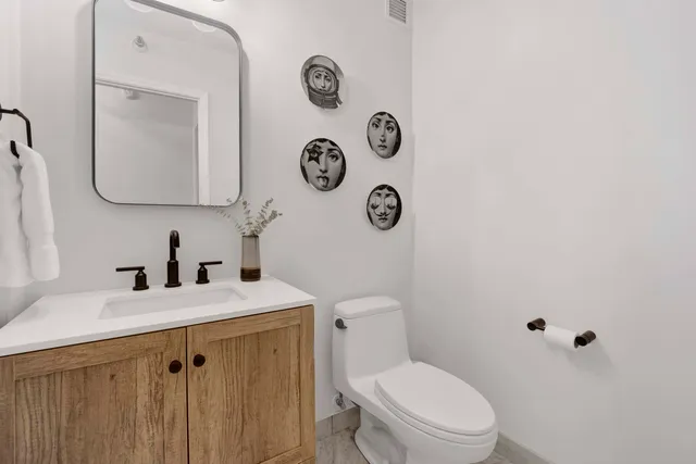 a bathroom with a sink vanity mirror and toilet