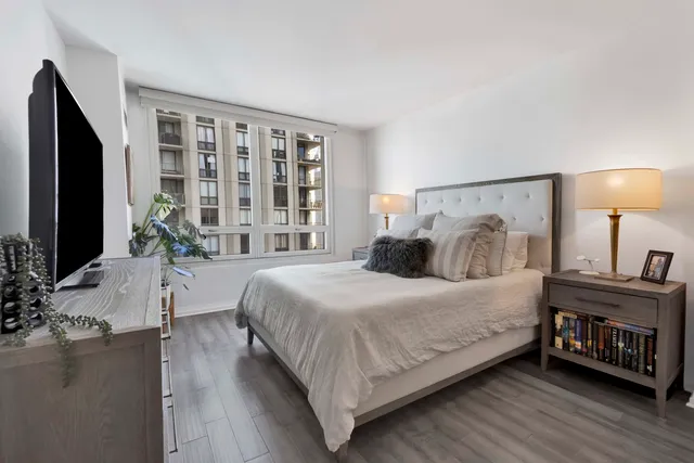 a bedroom with a large bed and a flat tv screen on a dresser