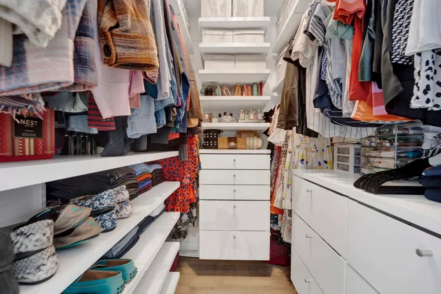 a view of walk in closet with clothes and shoes