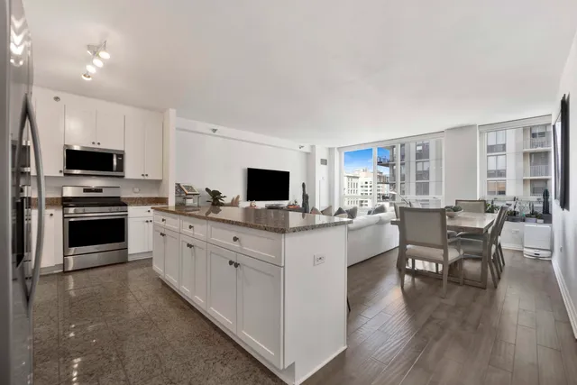 a large kitchen with cabinets wooden floor and stainless steel appliances