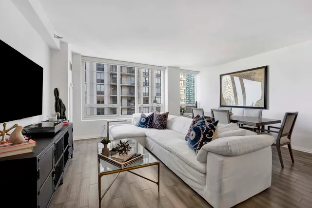 a living room with furniture a flat screen tv and a window