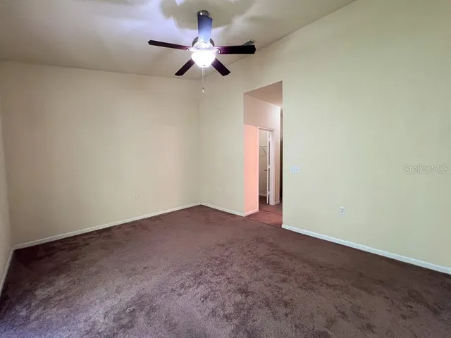 an empty room with a ceiling fan and a fan
