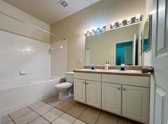 a bathroom with a double vanity sink mirror and toilet
