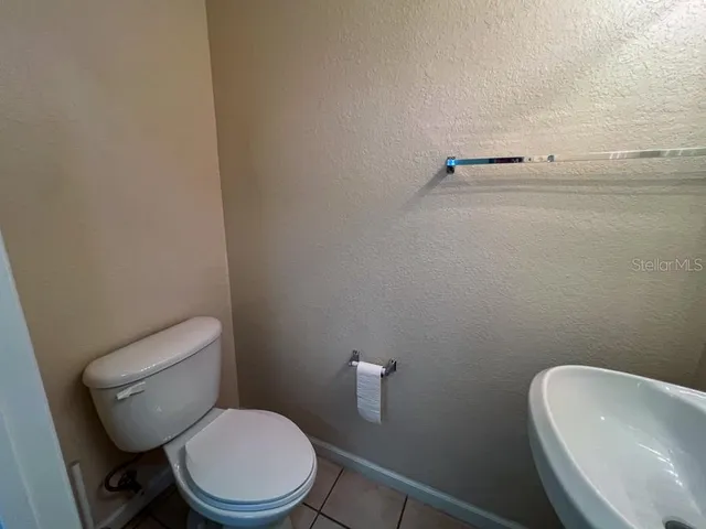 a white toilet sitting next to a white sink and vanity