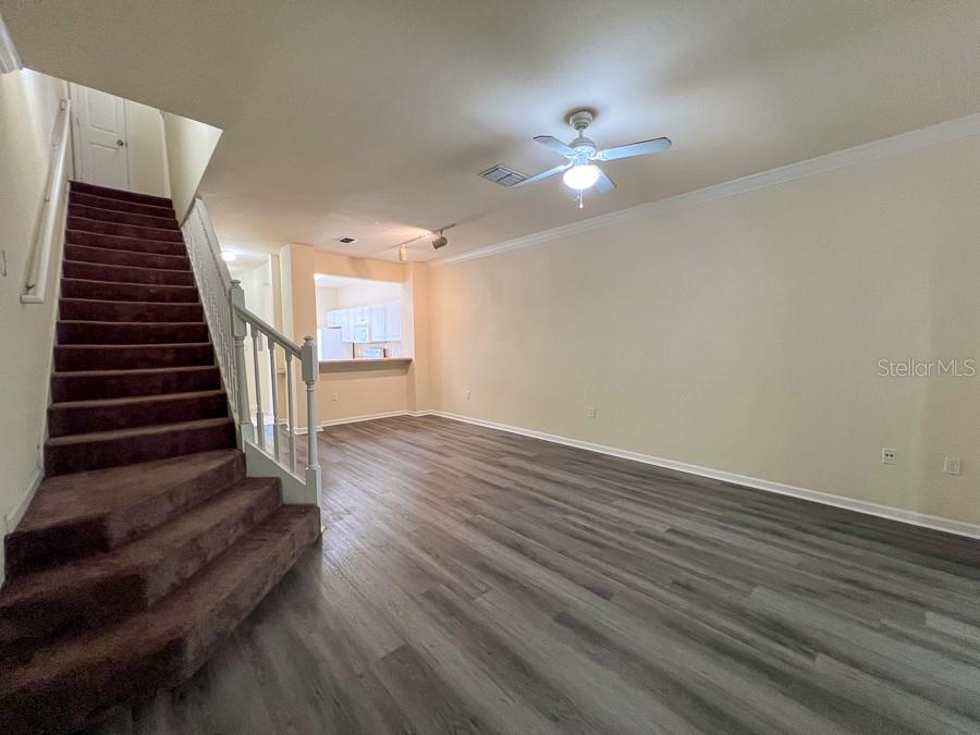 4886 Northwest 46th Place, Unit 106 Gainesville, FL 32606 - Photo 27 of 29 wooden floor in an empty room with a chandelier