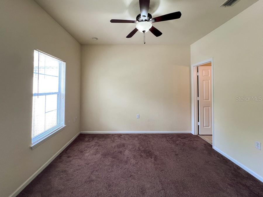 4886 Northwest 46th Place, Unit 106 Gainesville, FL 32606 - Photo 28 of 29 an empty room with windows and fan
