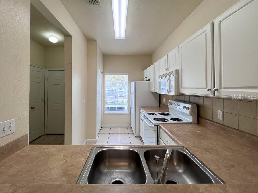 4886 Northwest 46th Place, Unit 106 Gainesville, FL 32606 - Photo 4 of 29 a kitchen with stainless steel appliances granite countertop a sink a stove and a refrigerator