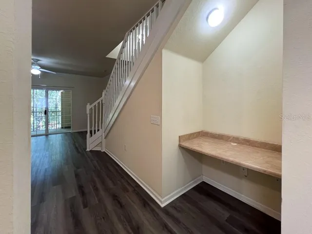 a hallway with wooden floor and stairs