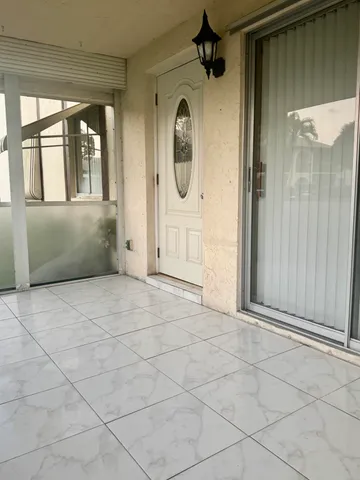 an empty room with mirror and windows