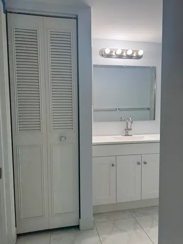 a bathroom with a sink a mirror and cabinets