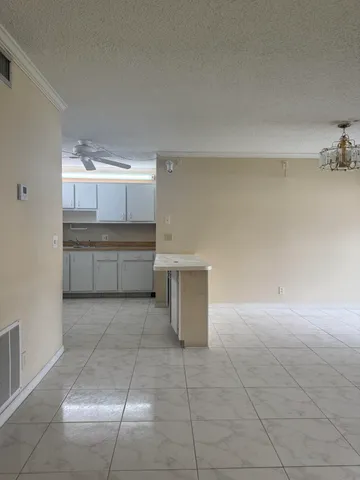 a view of kitchen and empty room with windows