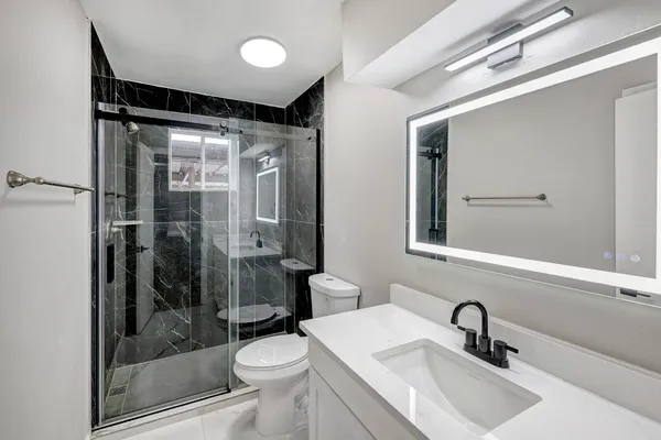 a bathroom with a sink shower and a toilet
