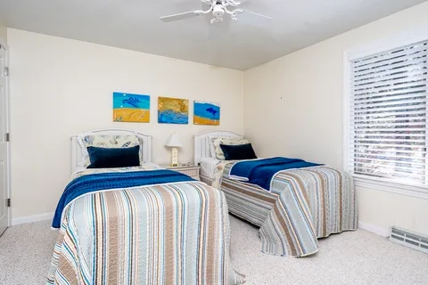 a bedroom with two beds and a chandelier