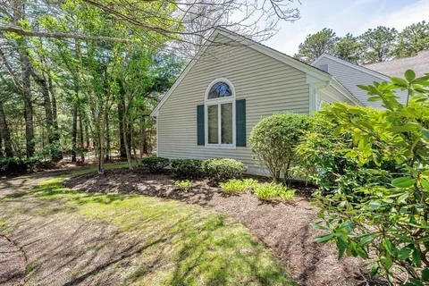 a view of a house with backyard and sitting area