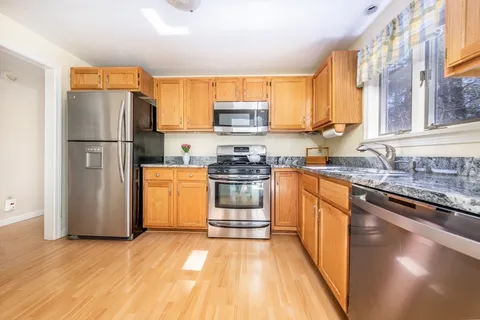 a kitchen with a refrigerator a stove top oven a sink and cabinets