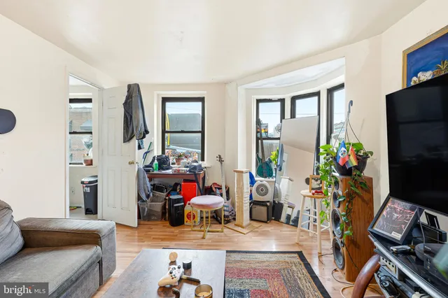 a living room with furniture a flat screen tv and a table