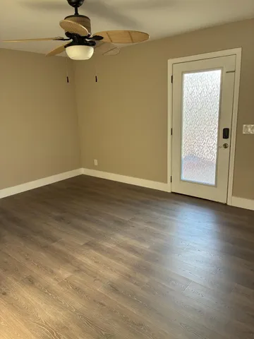 a view of an empty room with wooden floor