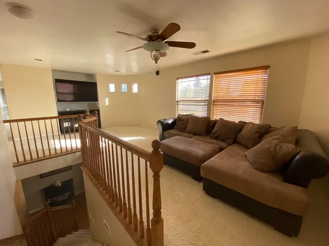 a living room with furniture ceiling fan and a window
