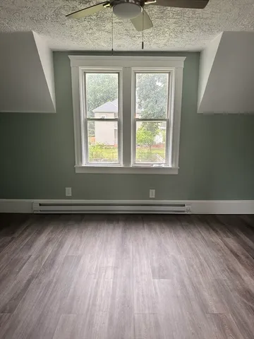 an empty room with wooden floor and window