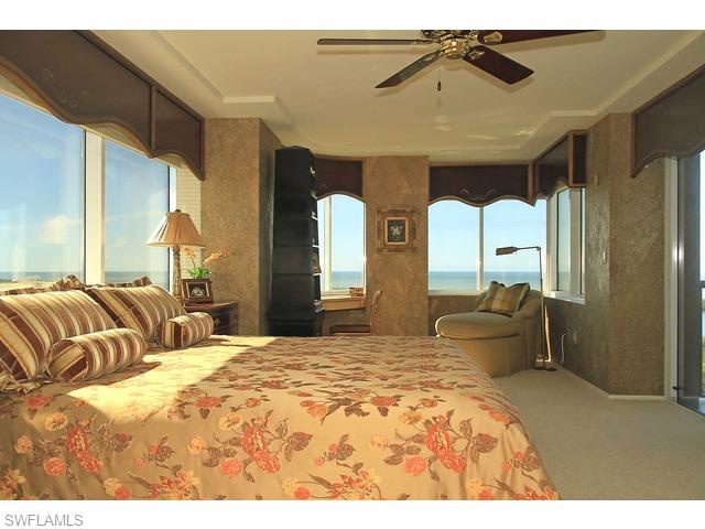6825 Grenadier Boulevard Naples, FL 34108 - Photo 3 of 11 a bedroom with a large bed and a chandelier