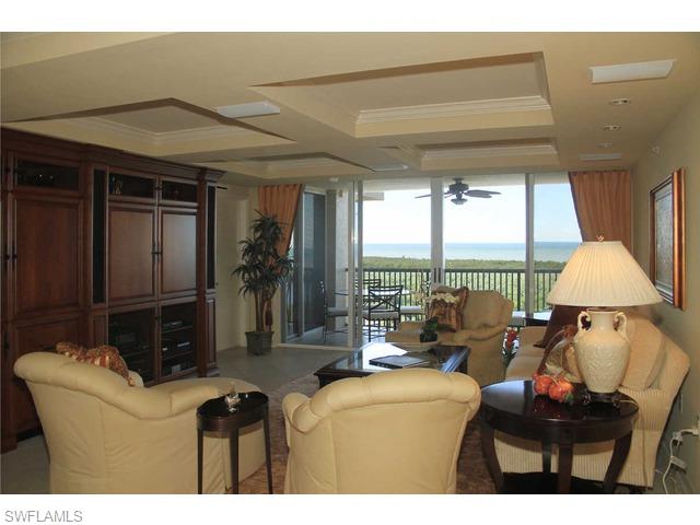 6825 Grenadier Boulevard Naples, FL 34108 - Photo 4 of 11 a living room with furniture and a floor to ceiling window
