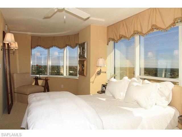 6825 Grenadier Boulevard Naples, FL 34108 - Photo 5 of 11 a bedroom with a large bed and a large window