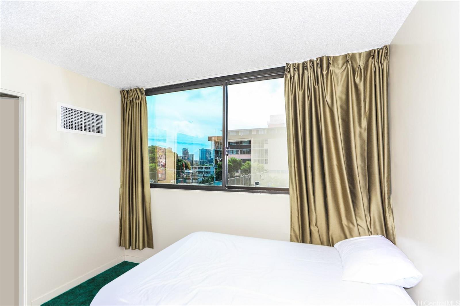 1114 Punahou Street, Unit 3B Honolulu, HI 96826 - Photo 14 of 25 a bedroom with a large window and a bed
