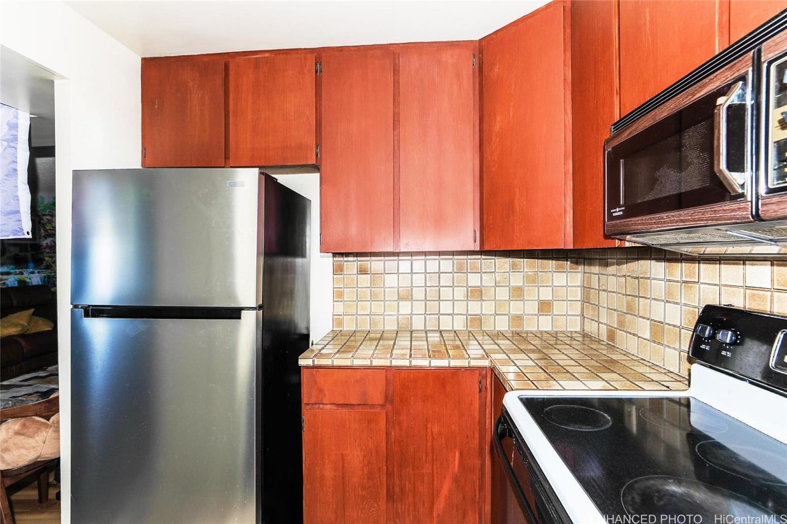 1114 Punahou Street, Unit 3B Honolulu, HI 96826 - Photo 9 of 25 a kitchen with stainless steel appliances granite countertop a refrigerator and a microwave