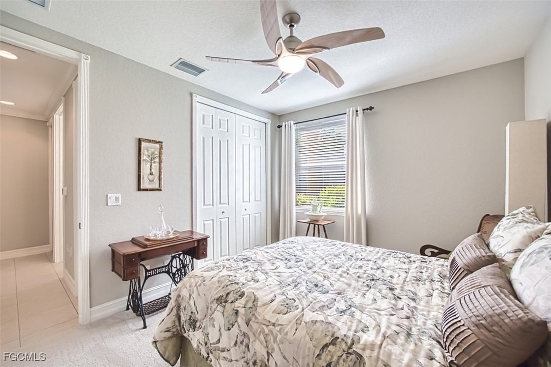 12129 Lucca Street, Unit 102 Fort Myers, FL 33966 - Photo 24 of 40 a bedroom with a bed and a chandelier