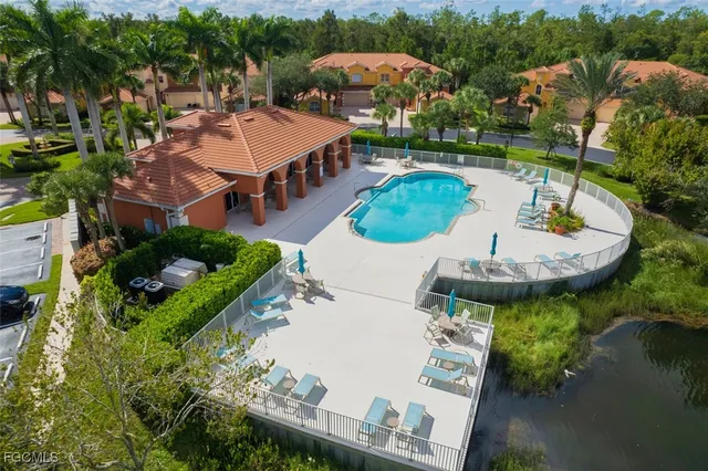 an aerial view of a house with outdoor space pool patio and lake view