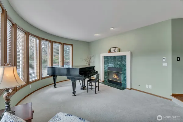 a livingroom with furniture a fireplace and windows