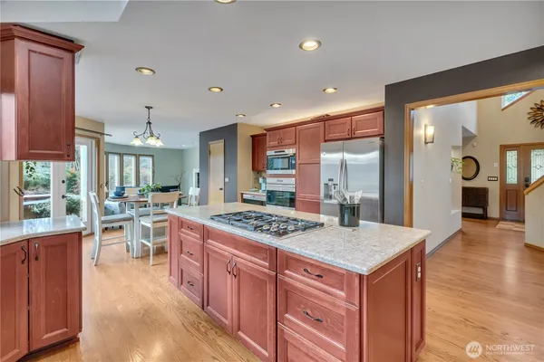 a kitchen with kitchen island granite countertop lots of counter top space and stainless steel appliances