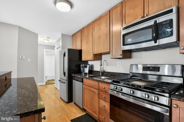 a kitchen with stainless steel appliances granite countertop a stove a refrigerator and a microwave