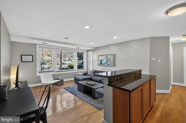 a living room with furniture a large window and wooden floor