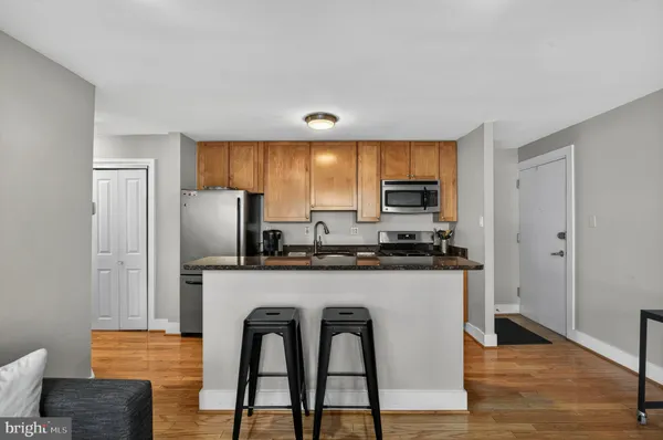 a kitchen with stainless steel appliances granite countertop a refrigerator a stove top oven a sink and dishwasher