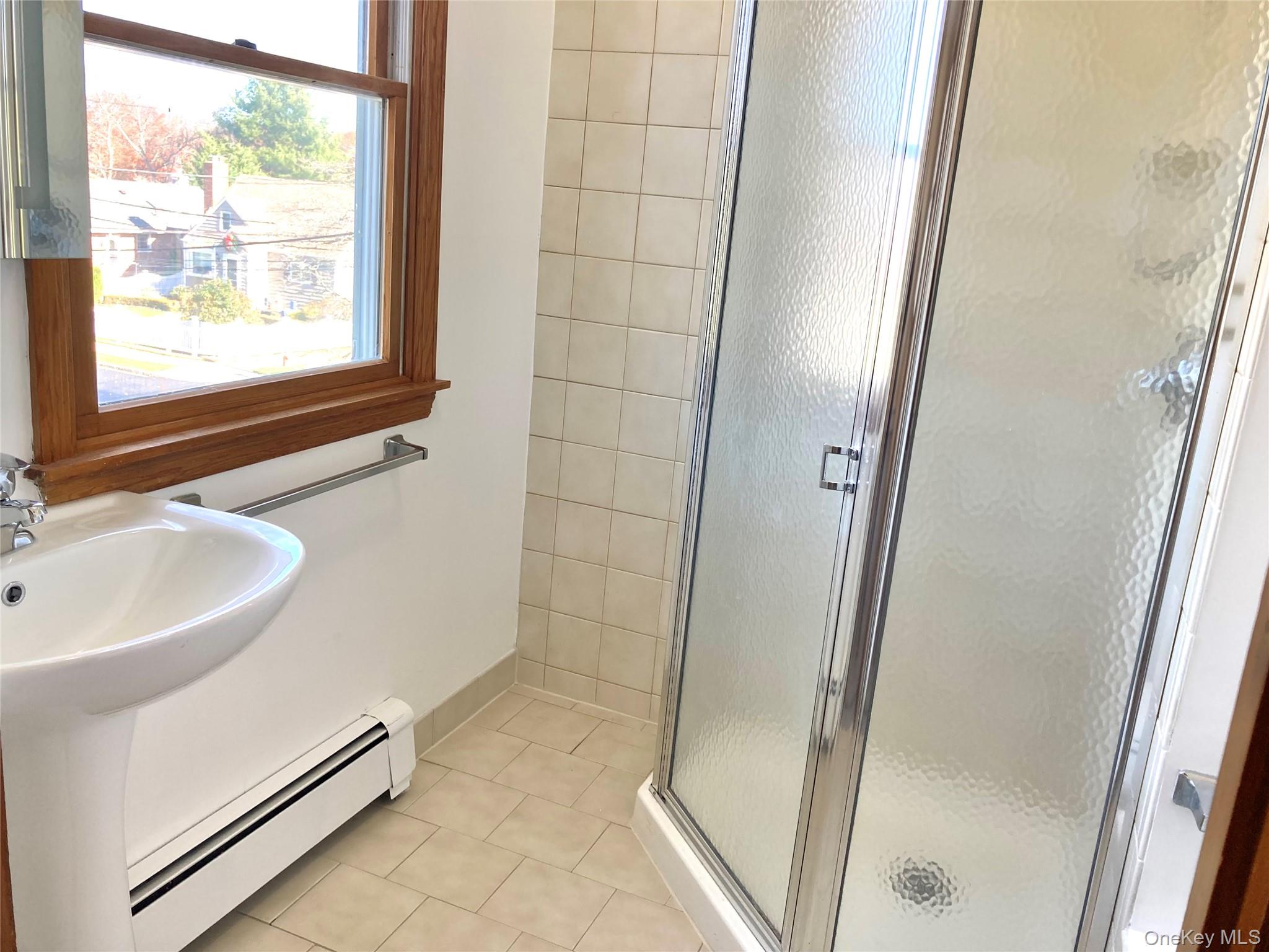 12 Soundview Avenue, Unit UPPR Oyster Bay, NY 11771 - Photo 17 of 20 a bathroom with a sink a mirror and a shower