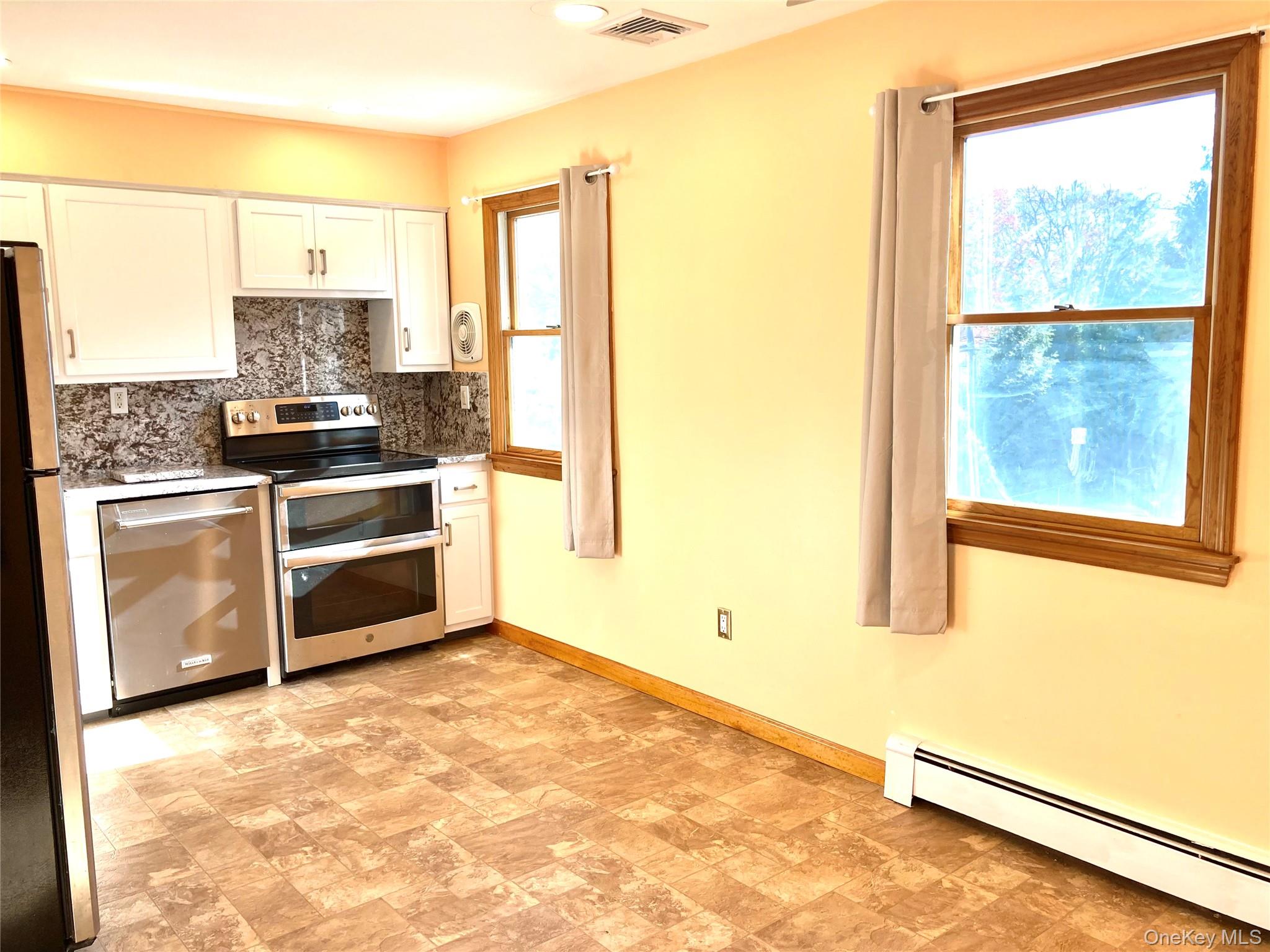 12 Soundview Avenue, Unit UPPR Oyster Bay, NY 11771 - Photo 6 of 20 a kitchen with a stove a sink and a refrigerator