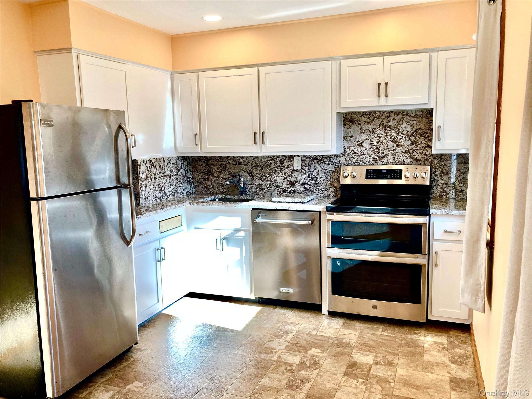 12 Soundview Avenue, Unit UPPR Oyster Bay, NY 11771 - Photo 7 of 20 a kitchen with granite countertop a refrigerator stove and cabinets