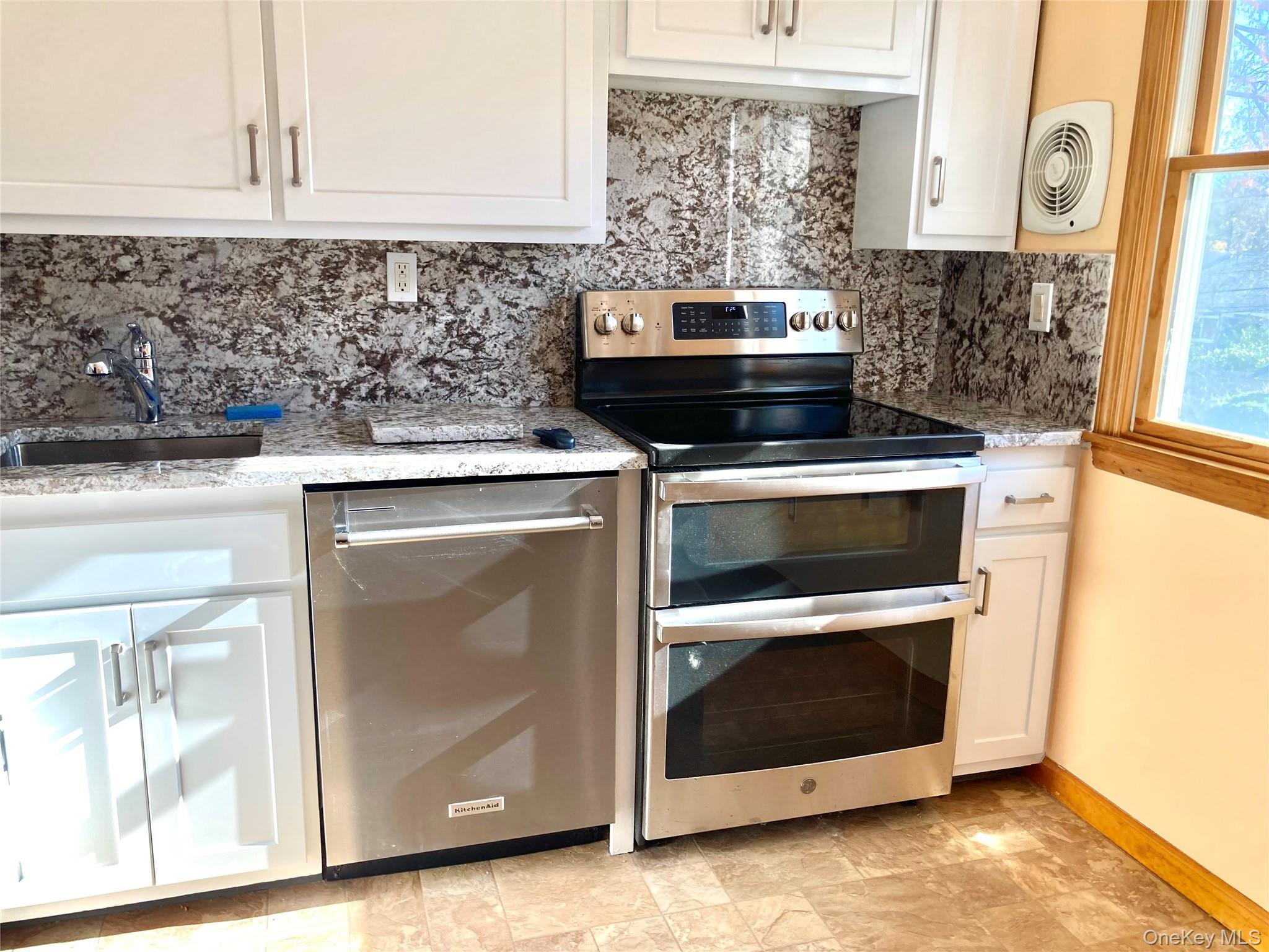 12 Soundview Avenue, Unit UPPR Oyster Bay, NY 11771 - Photo 8 of 20 a kitchen with a stove and a microwave