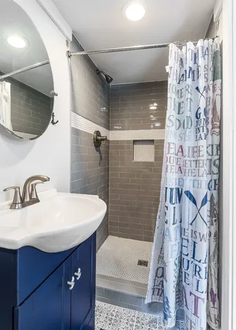 a bathroom with a sink a toilet and shower