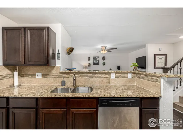 a kitchen with granite countertop a sink a stove and cabinets