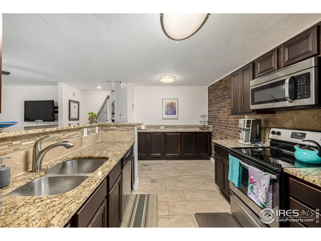 a kitchen with stainless steel appliances granite countertop a sink a stove and a microwave oven