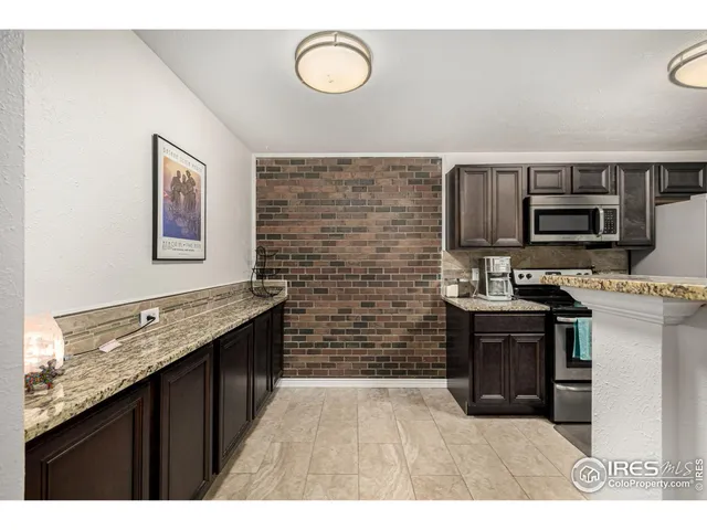 a kitchen with kitchen island granite countertop a stove top oven microwave and cabinets